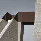 La scala, realizzata in pietra, � staccata dal corpo dell�edificio. A collegarla con la torre c'� un ponticello rossiccio di corten, tipologia di acciaio preossidato particolarmente resistente